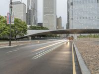 city street and road with highway with bus lanes in the evening time, and skyscrapers in the background