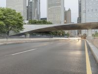 city street and road with highway with bus lanes in the evening time, and skyscrapers in the background