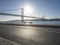 a person is running and riding on the street near the water below the bridge in the evening