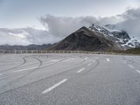 this is an image of an empty highway with mountains and a sky background at the top