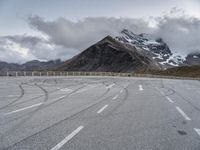 this is an image of an empty highway with mountains and a sky background at the top