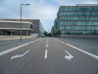 the road is empty on this busy street with the tall building in the background for pedestrians