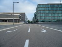 the road is empty on this busy street with the tall building in the background for pedestrians