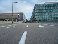 the road is empty on this busy street with the tall building in the background for pedestrians