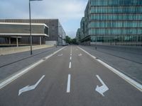 the road is empty on this busy street with the tall building in the background for pedestrians