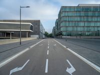the road is empty on this busy street with the tall building in the background for pedestrians