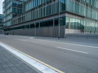 the road is empty on this busy street with the tall building in the background for pedestrians