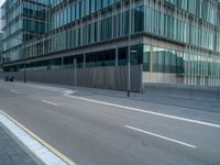 the road is empty on this busy street with the tall building in the background for pedestrians