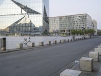 two bicycles parked on a city street in front of some modern buildings that are reflecting their reflective glass