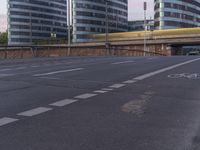 two buildings that are beside a bicycle path and road bridge with a bullet on the road