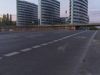 two buildings that are beside a bicycle path and road bridge with a bullet on the road