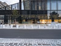 there are white pillars on the side of a building in the street by a fence