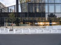 there are white pillars on the side of a building in the street by a fence