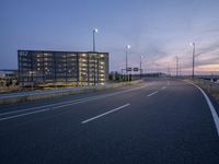 a very empty highway with some traffic lights and buildings in the background for a beautiful shot