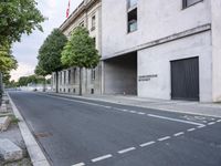 the empty street in front of a large building is empty and is not visible yet