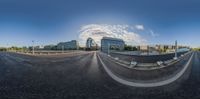 a fisheye lens is showing some kind of road near a large building and cars