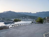 a parking lot with the view of the water in the distance and mountains surrounding it