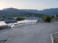 a parking lot with the view of the water in the distance and mountains surrounding it