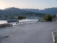 a parking lot with the view of the water in the distance and mountains surrounding it