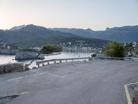 a parking lot with the view of the water in the distance and mountains surrounding it