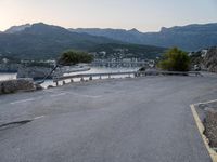 a parking lot with the view of the water in the distance and mountains surrounding it