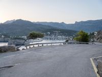 a parking lot with the view of the water in the distance and mountains surrounding it