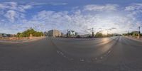 a 360 - view view of an empty street with houses in the back ground and trees on either side