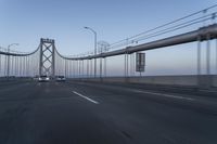 the view of the bridge from an approaching car on the road as seen from behind the windshield