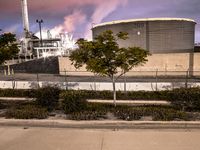 there is a fire hydrant and other trees and bushes in front of the factory