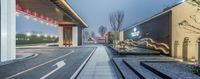 an entrance and walkway in china with a lit up billboard on the wall by the street