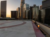 the buildings are in high rise for this photo of a large city at sunset with lights on the sidewalk