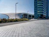 some building and some grass near a street lights and cars and buildings with a blue sky