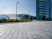 some building and some grass near a street lights and cars and buildings with a blue sky