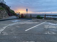 an empty parking lot with a view of a beautiful sunset over the city of san francisco