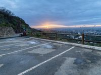 an empty parking lot with a view of a beautiful sunset over the city of san francisco