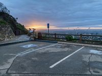 an empty parking lot with a view of a beautiful sunset over the city of san francisco