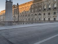 a traffic cone that is by the street on a sidewalk with some buildings in the background