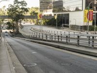 this is an empty road with traffic in the background and a sidewalk going through it