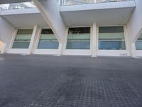 a view from outside on some buildings with windows and a sky line above them, and a person walking