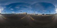 long shadows of an empty parking lot and street in a big cityscape with a cloudy blue sky