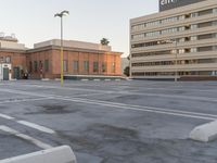 a parking lot full of a city bank building next to a street sign and a parking meter