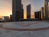 a city circle with skyscrapers in the background and a bench at the center of it