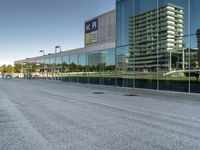 a view of an empty parking lot from another road with a reflection in the glass windows