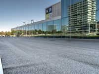 a view of an empty parking lot from another road with a reflection in the glass windows