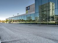 a view of an empty parking lot from another road with a reflection in the glass windows