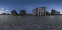 an image of the circular view of a city street in front of buildings and trees