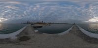 a view of a city through a fish eye lens by the water and pier area