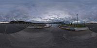 a fish eye lens is shown on a camera roll with clouds above the water and a small boat on a dock in front