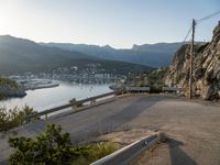 a very steep mountain side with a city on it next to the water and some mountains