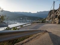 a very steep mountain side with a city on it next to the water and some mountains